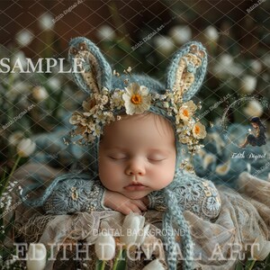 May include: A sleeping baby wearing a blue crocheted hat with a floral crown and a blue and white crocheted blanket. The baby is surrounded by a green and brown floral background.