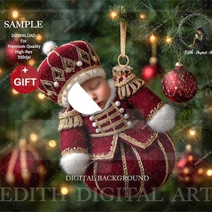 May include: A Christmas ornament shaped like a baby in a burgundy and gold military-style outfit. The ornament has a white fur trim and is hanging from a gold string. The background is a Christmas tree with red ornaments and lights. The text "GIFT" is visible.