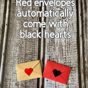 May include: Two envelopes, one red and one brown, with hearts on the front. The red envelope has a black heart, and the brown envelope has a red heart. The text "Red envelopes automatically come with black hearts" is written on a wooden background.
