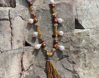 Super fun and shiny gold toned tassel attached to beaded freshwater pearls, citrine, crystal and rutilated quartz.