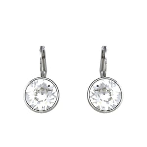 May include: A pair of silver earrings with a clear crystal stone in the center of each earring.