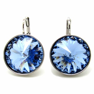 May include: A pair of silver dangle earrings with light blue crystal stones. The stones are round and have a faceted design.
