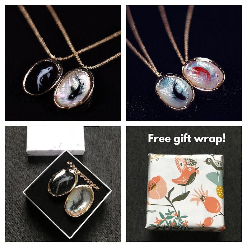 May include: Two gold necklaces with black and white fish pendants. The necklaces are displayed on a white surface with a white box. The text "Free gift wrap!" is displayed on a white background with a colorful floral pattern.