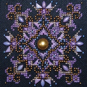 Könnte beinhalten: Ein violettes und goldenes Perlen-Schneeflocken-Design auf einem schwarzen Stoffhintergrund.