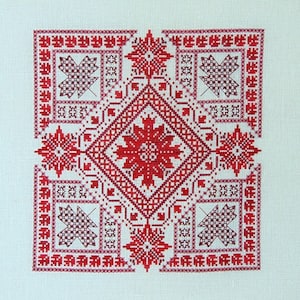 May include: Red and white cross-stitch pattern with a central diamond shape and four corner designs. The pattern is framed by a border of red and white squares.