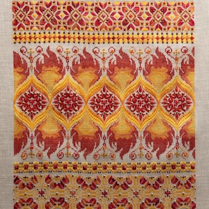 May include: A cross-stitch embroidery design featuring a repeating pattern of stylized flames in shades of red, orange, and yellow. The design is framed by a border of geometric shapes and beads.