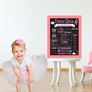 May include: A pink and black chalkboard sign with the text "Emma-Claire My 2nd Birthday!"  The sign lists the child's age, weight, height, favorite foods, and other details.  The sign is decorated with pink and white ballet shoes and a pink heart.
