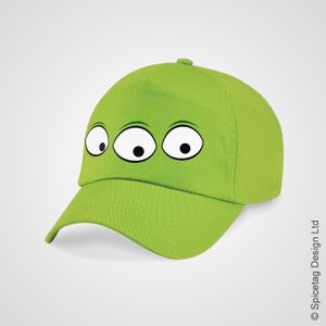May include: A green baseball cap with three cartoon eyes on the front.
