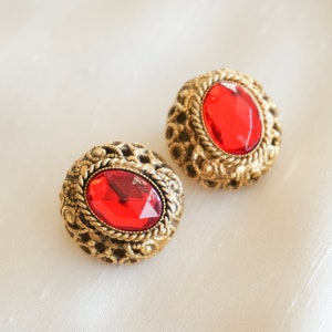 Peut inclure: Une paire de boucles d'oreilles en or avec des pierres ovales rouges serties dans un motif de filigrane.