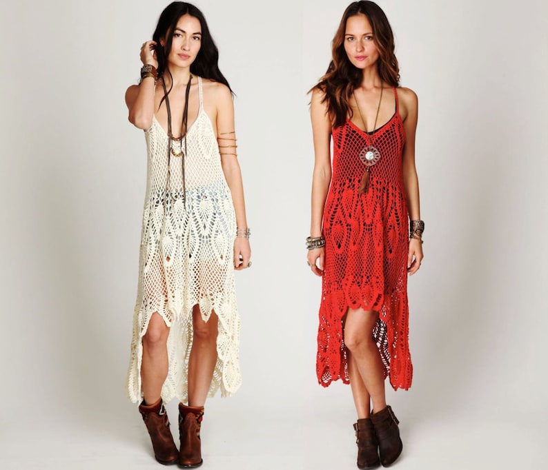 May include: Two women wearing crochet dresses. The dress on the left is white and the dress on the right is red. Both dresses are high-low style with a shorter front and longer back.