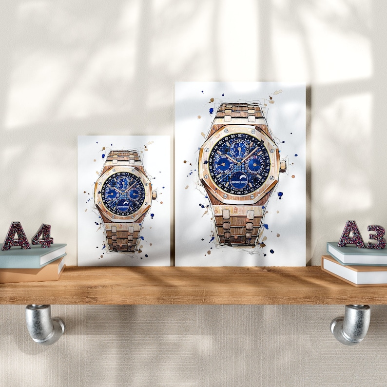 May include: Two watercolor prints of a luxury watch with a blue face and gold-toned metal band. The watch design is detailed with a moon phase indicator. The prints are displayed on a wooden shelf with decorative letters.