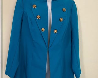 May include: A long teal blue blazer with a mandarin collar and gold buttons. The blazer has a single-breasted closure and long sleeves.