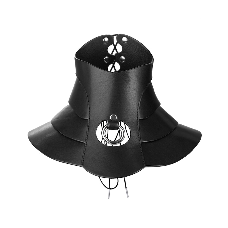 May include: A black faux leather choker collar featuring a multi-layered flared design. The piece includes a central silver-toned metal O-ring, silver eyelets, and black cord lacing at the back and bottom for an adjustable fit and secure closure.