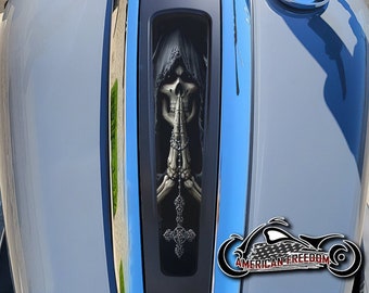 May include: A motorcycle gas tank with a black and silver Road Glide emblem. A black and white graphic of a skeleton in a hooded robe with a cross is on the tank.