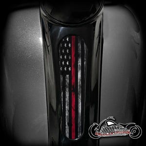 May include: A black motorcycle part with a distressed American flag design featuring a red stripe. The image includes the text "AMERICAN FREEDOM" and a motorcycle graphic.