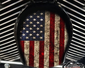 May include: A distressed American flag design on a black motorcycle air cleaner cover. The flag is faded and worn, with a vintage look.