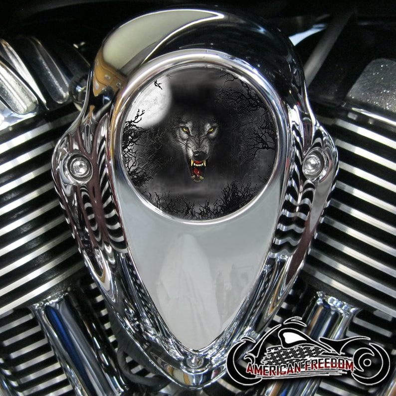 May include: Chrome motorcycle air cleaner cover with a black and white wolf graphic. The wolf is howling at the moon in a dark forest setting.