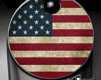 May include: A round, distressed American flag decal with a faded, vintage look. The flag is red, white, and blue with a circle of white stars on a blue background.