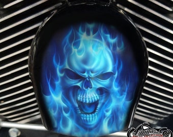 May include: A blue skull with flames, a motorcycle helmet cover.