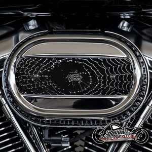 Pode incluir: Um close-up de um filtro de ar de motocicleta cromado com um design de teia de aranha preta. O filtro de ar tem forma oval e um acabamento cromado brilhante. O design da teia de aranha é intrincado e detalhado, e é visível através do cromo.