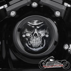 Puede incluir: Cubierta de motor de motocicleta negra con un diseño de calavera. La calavera está detallada en tonos grises y blancos, sobre un fondo negro. La imagen incluye el texto "AMERICAN FREEDOM" y un gráfico de motocicleta.
