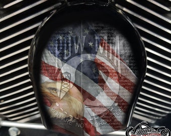 May include: A close-up of a motorcycle's chrome petrol tank with an American flag and eagle design. The flag is faded and has a list of names and locations printed on it. The text reads "You are not forgotten".