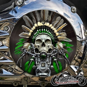 Puede incluir: Una pieza cromada de motocicleta con una calavera que lleva un tocado nativo americano con detalles en verde y blanco. La calavera está colocada sobre el manillar y el motor de una motocicleta. Incluye el texto "AMERICAN FREEDOM".