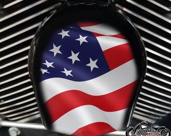 May include: A black motorcycle air cleaner cover featuring an American flag design. The flag is red, white and blue and is waving in the wind.