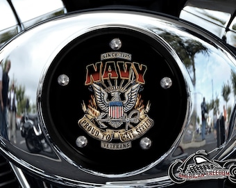 Op de afbeelding: Een chromen motoraccessoire met een zwarte achtergrond met een Navy-embleem met een adelaar, een anker en de woorden "Since 1775 Navy Proud to Have Served Veterans".
