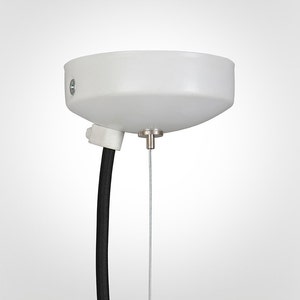 May include: White ceiling mount with a black wire and a silver cable hanging down.