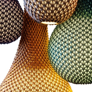 May include: Four hanging light fixtures made of woven material in blue, brown, green, and grey colours. The light fixtures are round and have a textured surface.