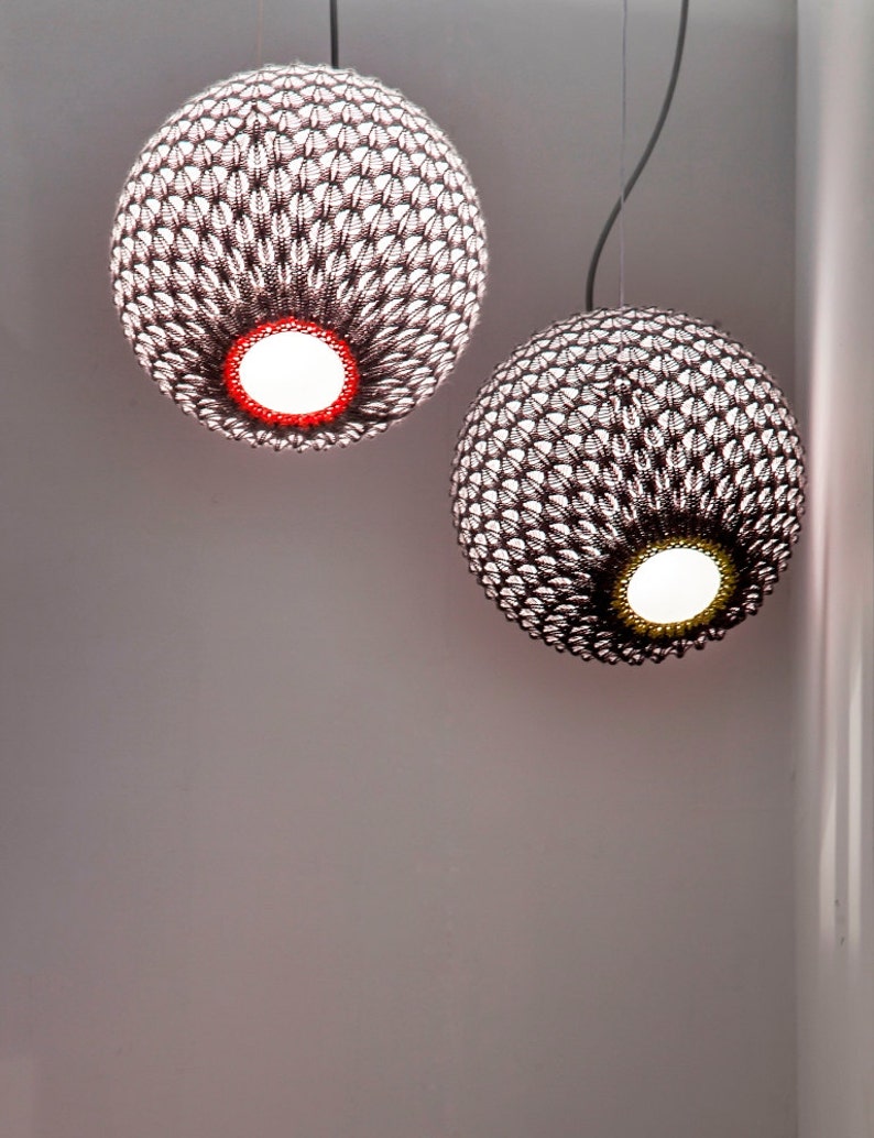 May include: Two hanging pendant lights with a woven, textured, brown and white pattern. The lights are round and have a white lightbulb inside.