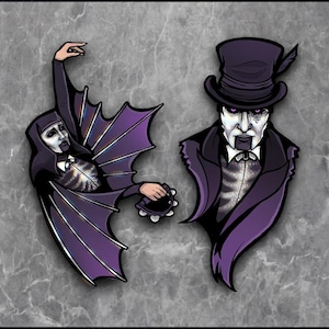 Puede incluir: Dos ilustraciones estilizadas de figuras con atuendos oscuros. Una figura, con rostro pálido, lleva una capa con alas de murciélago y sostiene una pandereta. La otra figura, también de rostro pálido, lleva un sombrero de copa y un abrigo largo. Ambas figuras tienen detalles morados.