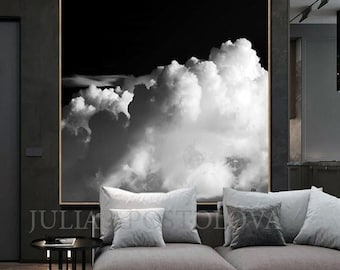 May include: A large square wall art piece featuring a high-contrast black and white photograph of voluminous, textured clouds against a dark sky. The artwork is framed in a thin, light-colored wood border and hangs centered on a dark wall.