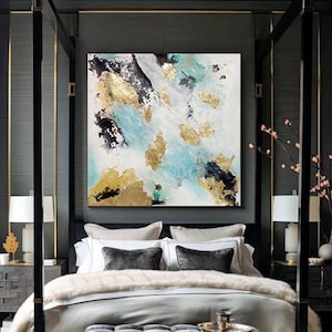 A modern and luxurious bedroom with a large bed, gray and white bedding, and an elegant neutral original painting on the wall , featured white, black gold and teal colors. The room has large windows, dark wood furniture, and plush seating areas.
