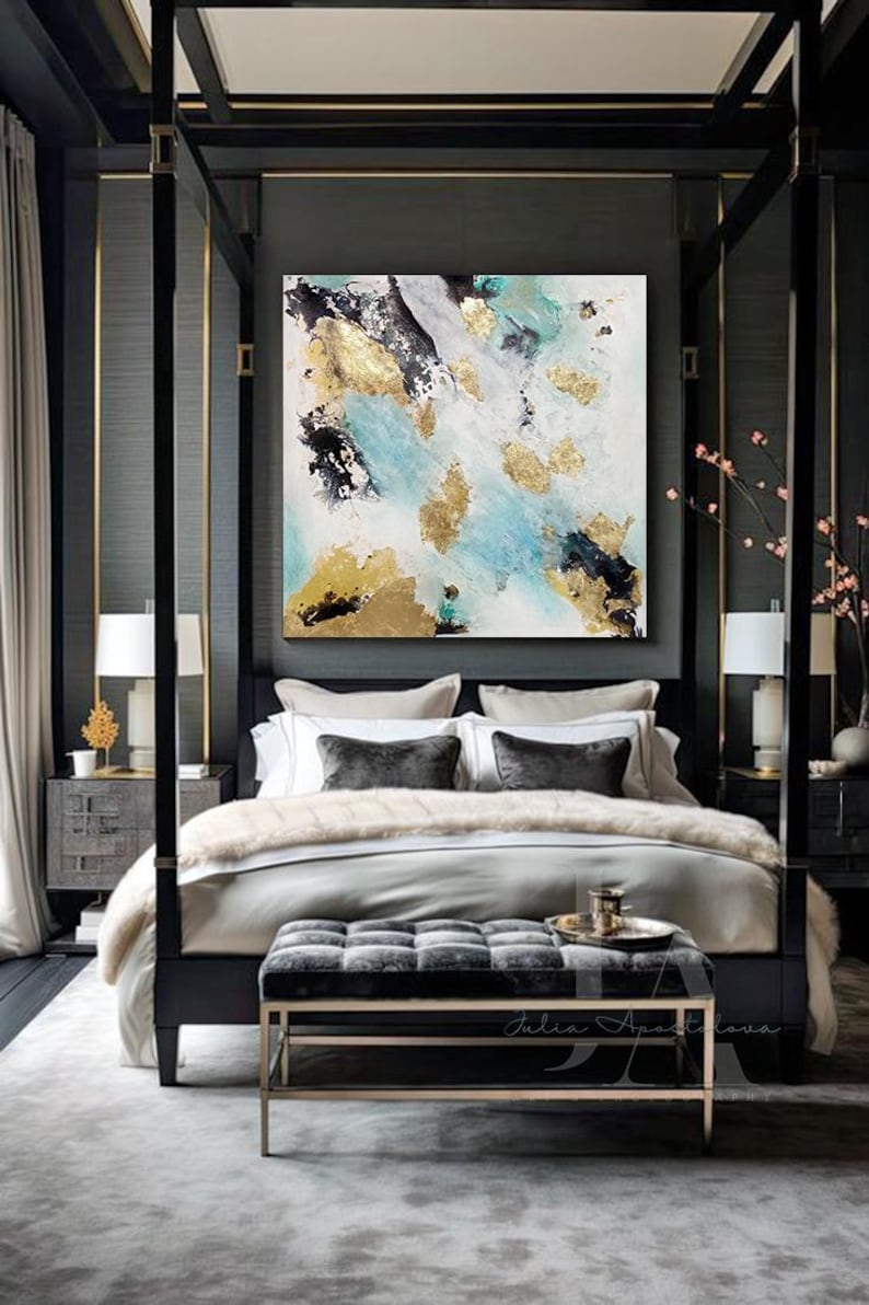 A modern and luxurious bedroom with a large bed, gray and white bedding, and an elegant neutral original painting on the wall , featured white, black gold and teal colors. The room has large windows, dark wood furniture, and plush seating areas.