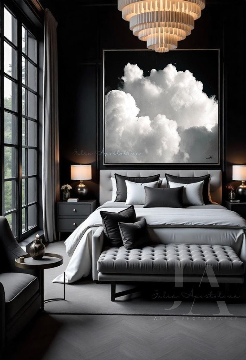 Classic style bedroom, with large black white cloud painting, by Julia Apostolova on the wall, a low couch surrounded by cushions. 
The room features dark gray black tones, and minimalist modern decor, creating a calming and harmonious atmosphere.