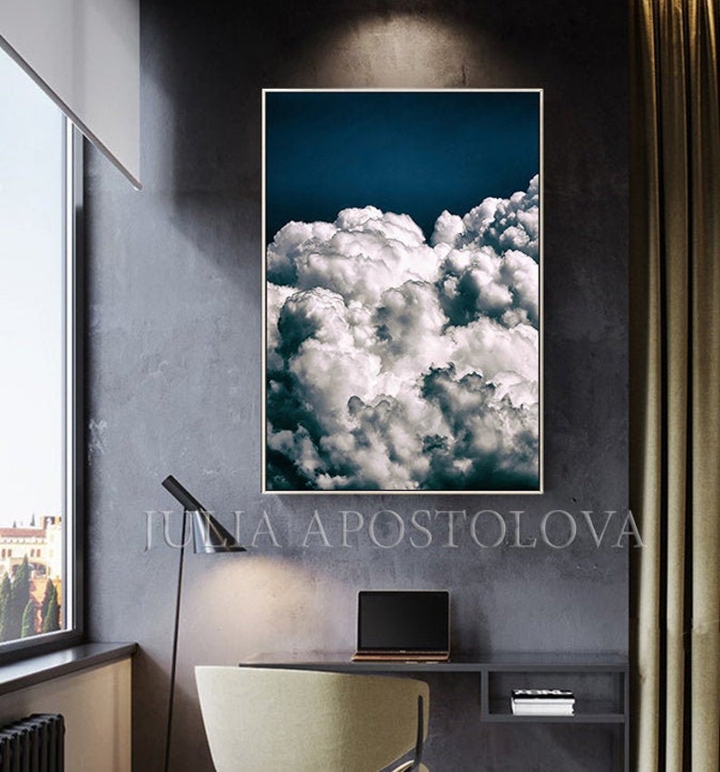 May include: A framed photograph of a dramatic, white, fluffy cloud formation against a dark blue sky. The clouds are arranged in a swirling, abstract pattern.