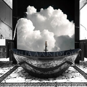 A luxurious black and white bathroom with a marble bathtub. The tub is the focal point, with a unique design and the name "JULIA APOSTOLOVA" printed on the side. A large cloudscape mural is visible in the background.