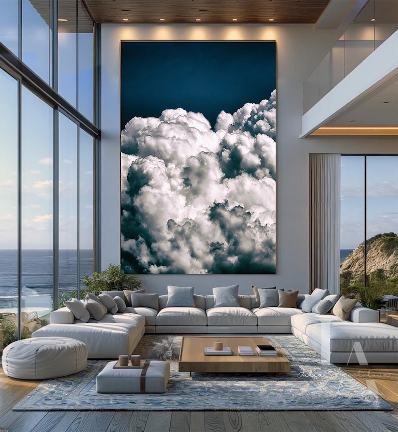 May include: A large, abstract painting of white clouds against a dark blue sky. The painting is hanging on a wall in a modern living room with a large sectional sofa and a coffee table.
