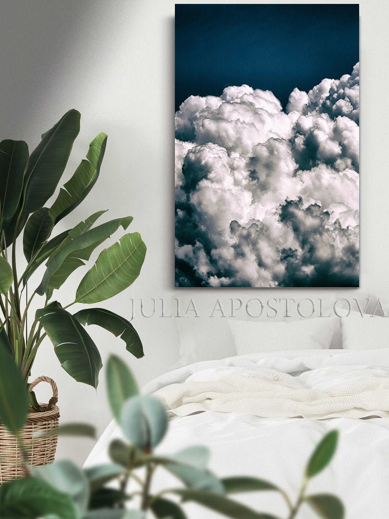May include: A photograph of a white fluffy cloud formation against a deep blue sky. The clouds are large and puffy, filling the entire frame. The image is taken from a low angle, giving the viewer a sense of being surrounded by the clouds.