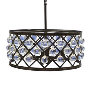 Op de afbeelding: Een decoratieve kroonluchter met een donker bronzen metalen frame en een ruitpatroon. Heldere glazen bollen met blauwe accenten hangen aan het frame en creëren een unieke verlichtingsarmatuur. De kroonluchter hangt aan een centrale stang.