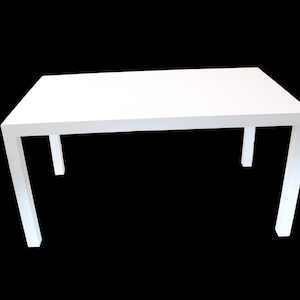 May include: A rectangular white table with four square legs. The table is a solid white color and appears to be made of wood or a similar material. The table is set against a black background.