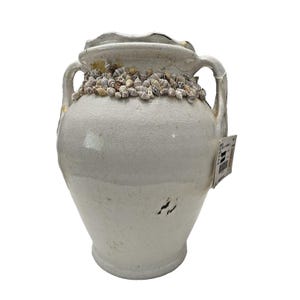 May include: A white ceramic mug with a black handle and the text "But First, Coffee" in a black, bold font. The mug is on a white surface.