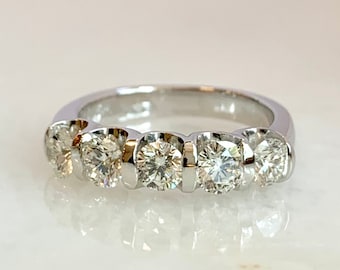 May include: A silver band ring with six round clear diamonds set in a row.
