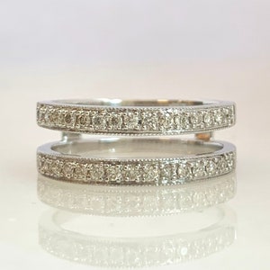 May include: A white gold ring with two bands of pave set diamonds.