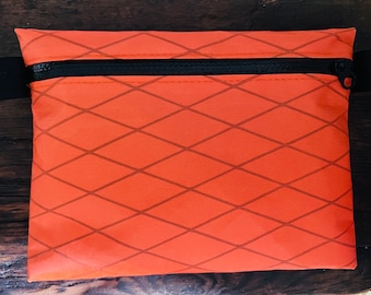 Estuche Xpac V07, cartera ultraligera en color naranja, con cremallera YKK negra impermeable.