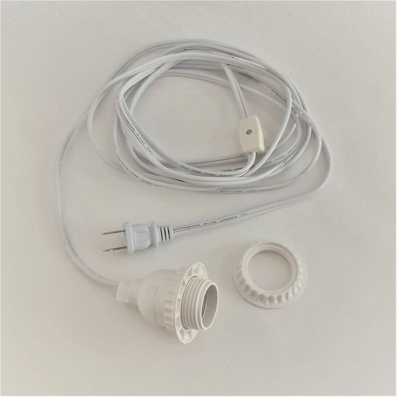 May include: White electrical cord with a plug, an inline switch, and a light socket. The cord is coiled and the socket is detached.