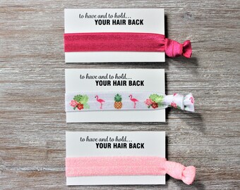 May include: Three hair ties with cards that say "to have and to hold... YOUR HAIR BACK". The hair ties are pink, white with pink flamingos and pineapples, and light pink.