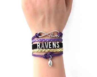May include: A multi-strand bracelet featuring purple and gold braided cords, a black band with the silver-toned text RAVENS, a silver infinity symbol charm with the word love, and a small silver-toned football charm hanging from a purple cord.